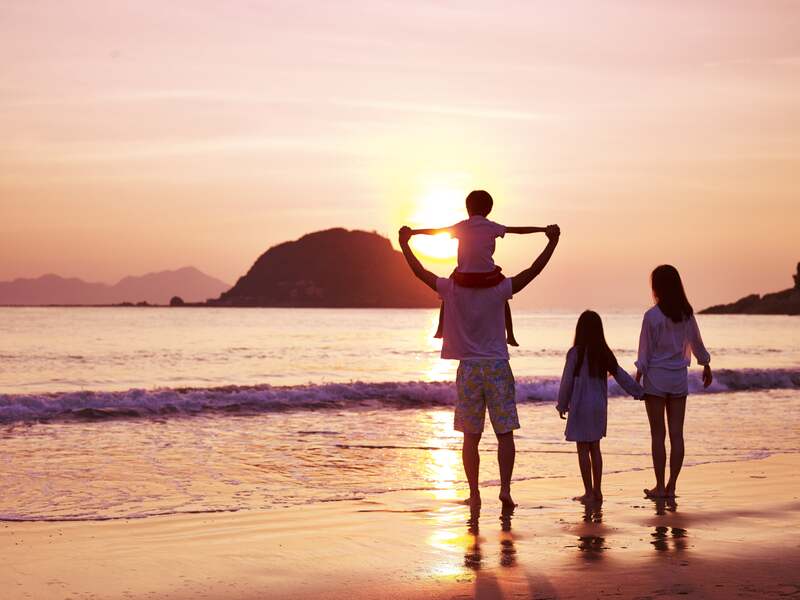 Family walking the beach at sunset