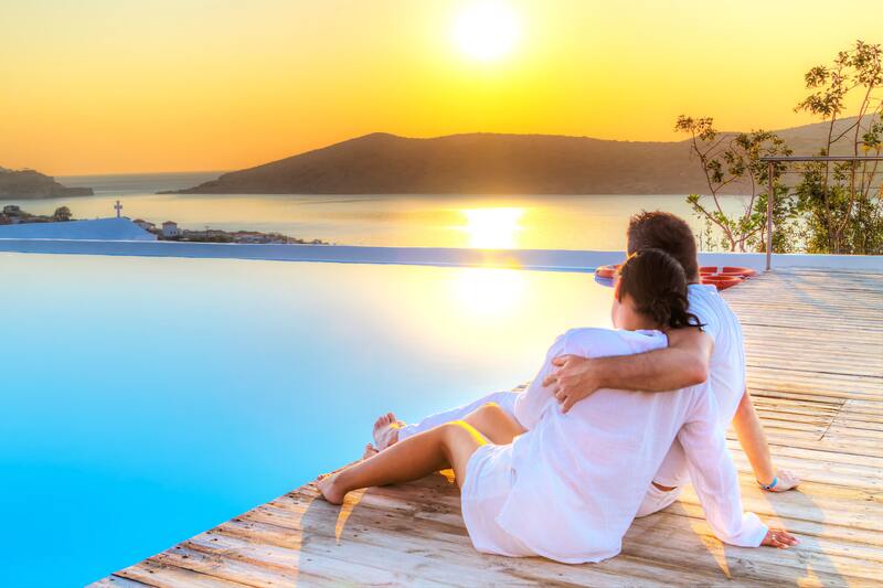 Couple enjoying Grecian sunset by pool